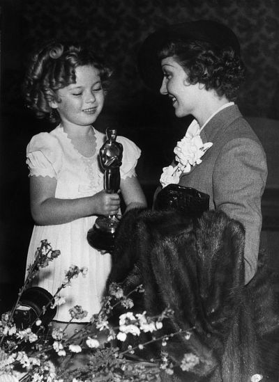 Shirley Temple presents the best actress Oscar to Colbert.