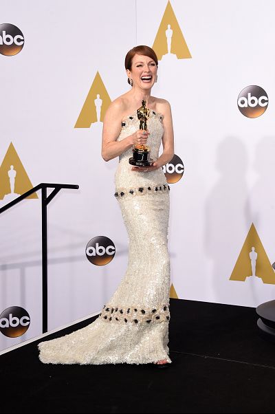 Julianne Moore joyously displays her award for best actress in 2015.