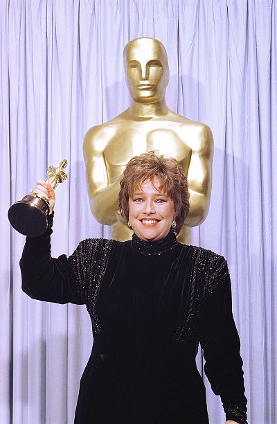 Hello, shoulder pads! Kathy Bates raises up the Oscar she won for her performance in "Misery."