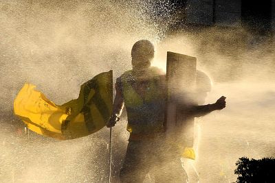 "Yellow vest" protesters are showered by a water cannon during clashes with police in Bordeaux, France, on Saturday.