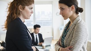Businesswomen glaring at each other in office
