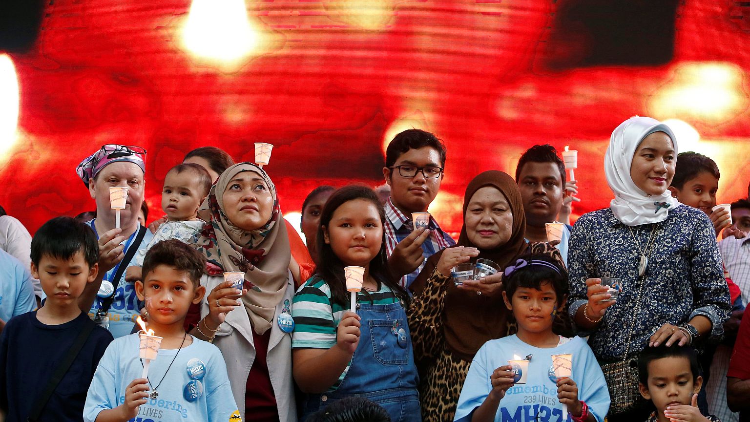 Image: Family members hold candles during the fifth annual remembrance even
