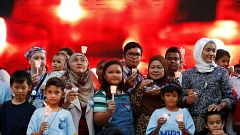 Image: Family members hold candles during the fifth annual remembrance even