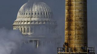 Image: The dome of the U.S. Capitol is seen behind the smokestack from the