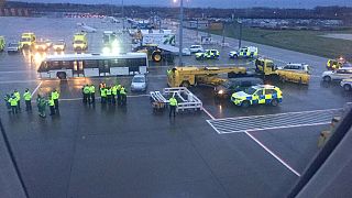 Image: Emergency personnel wait for passengers to disembark a flight from B