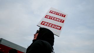 A supporter of Net Neutrality protests the FCC's recent decision to repeal 