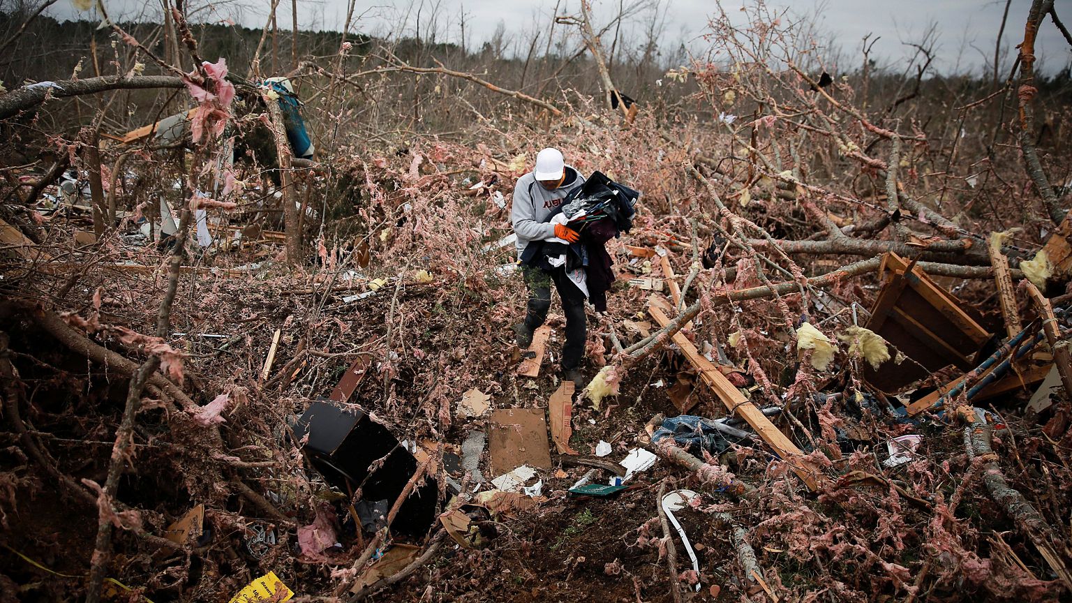 Image: Dax Leandro salvages clothing from the wreckage of his friend's home