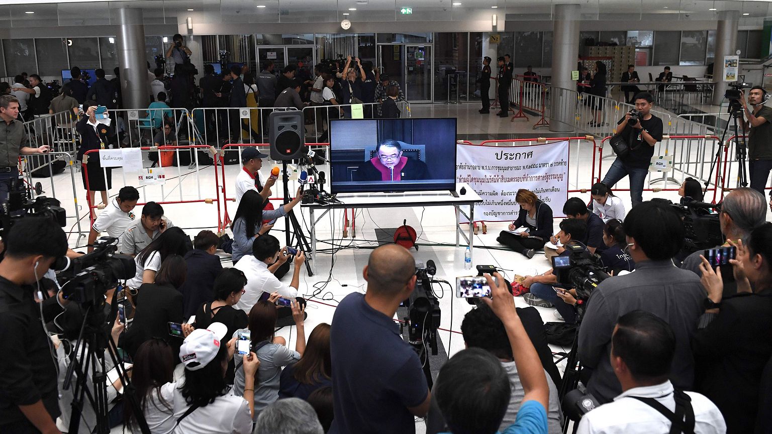 Image: Journalist records a live TV broadcast of a judge delivering the dec