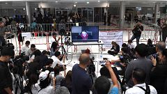 Image: Journalist records a live TV broadcast of a judge delivering the dec