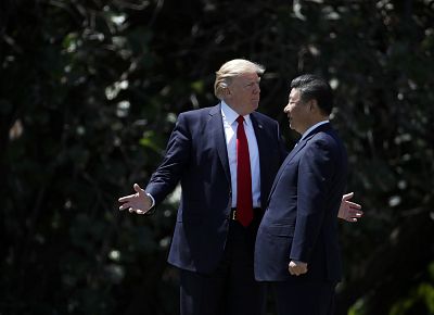 President Donald Trump gestures as he and Chinese President Xi Jinping walk together after their meetings at Mar-a-Lago on April 7, 2017 in Palm Beach, Fla.