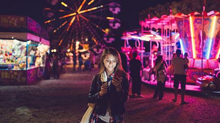 Image: Smiling woman texting at the amusement park