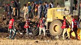 Image: Members of the search and rescue mission carry dead bodies at the sc
