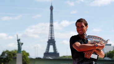 French Open champion Rafael Nadal relaxes with his trophy, the 10th Roland garros title of his career