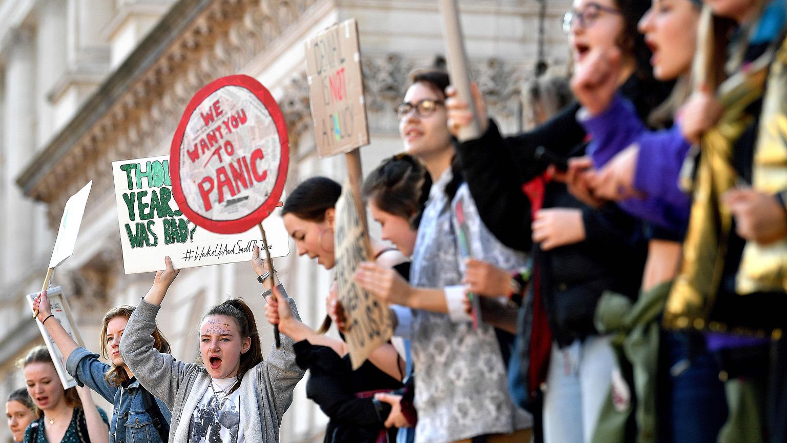 Image: Young demonstrators hold placards as they attend a climate change pr