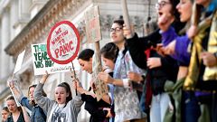 Image: Young demonstrators hold placards as they attend a climate change pr
