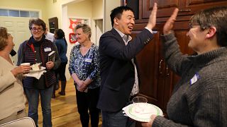 Image: Democratic presidential candidate Andrew Yang high fives with Charlo