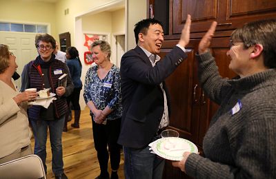 Democratic presidential candidate Andrew Yang high fives with Charlotte Fairlie at an activist event in Iowa City, Iowa, on March 10, 2019.