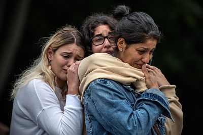 Young women comfort each other during a vigil near Al Noor mosque on March 18, 2019 in Christchurch, New Zealand.