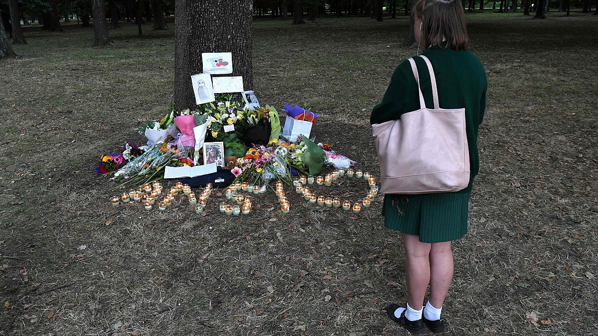 Image: A student pays respect at a memorial site for the victims of mosque 