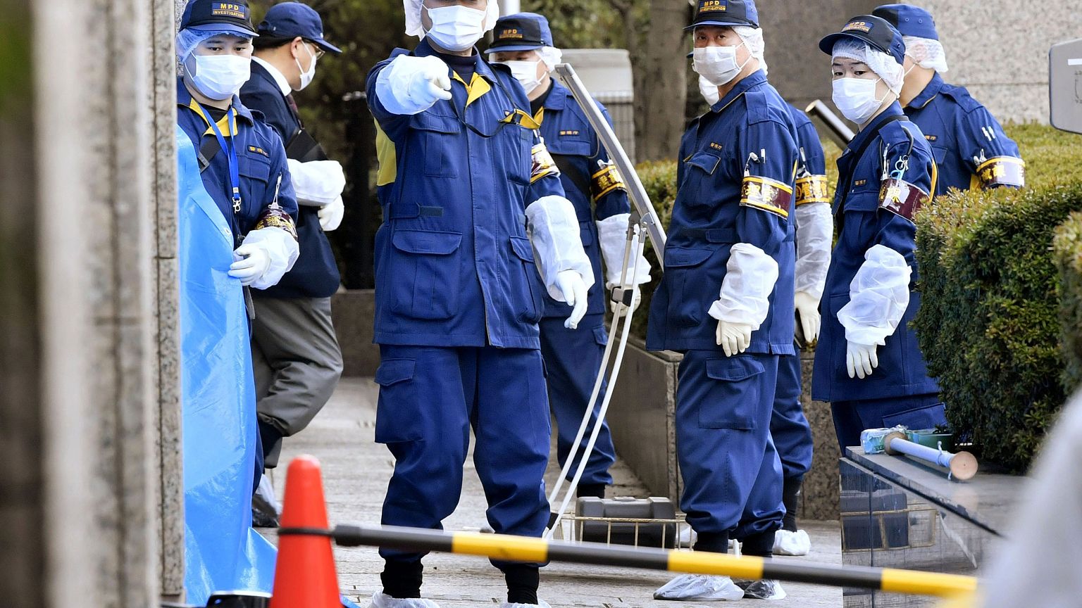 Image: Police investigate the scene after a woman was stabbed by her husban