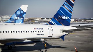 An airport worker fuels a JetBlue plane on the tarmac of the John F. Kenned