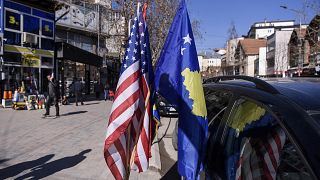 Image: U.S. and Kosovo flags displayed for sale in the street in the town o
