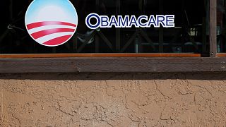Image: A sign on an insurance store advertises Obamacare in San Ysidro