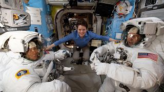 Image: NASA astronaut Anne McClain assists fellow astronauts Christina Koch