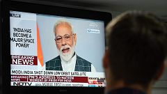 Image: A man watches Indian Prime Minister Narendra Modi's address to the n