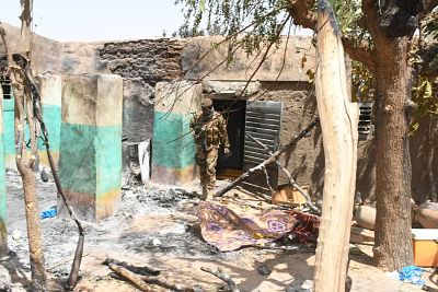 A soldier walks amid the damage after an attack by gunmen on Fulani herders on Monday.