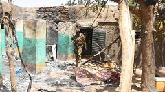 Image: A soldier walks amid the damage after an attack by gunmen on Fulani 