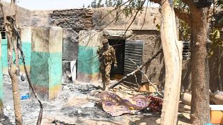 Image: A soldier walks amid the damage after an attack by gunmen on Fulani 