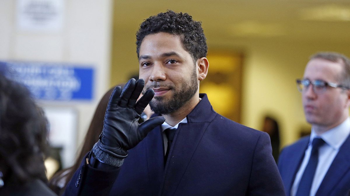 Image: Actor Jussie Smollett waves as he follows his attorney to the microp