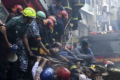 Bangladeshi firefighters rescue a man from a burning office building in Dhaka on March 28, 2019.