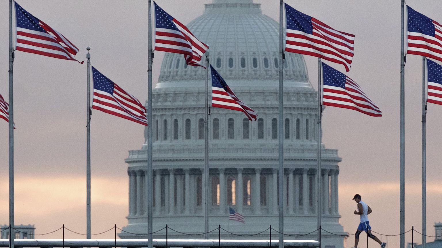Image: An early morning runner crosses in front of the U.S. Capitol