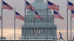 Image: An early morning runner crosses in front of the U.S. Capitol