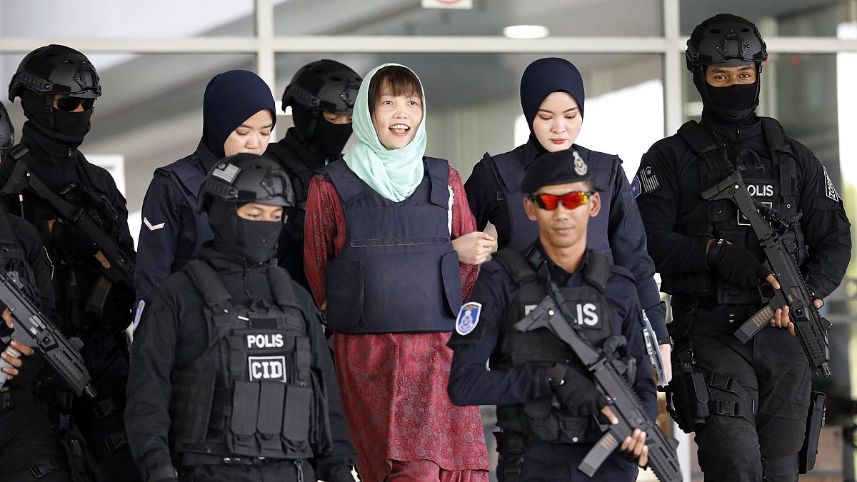 Image: Vietnamese Doan Thi Huong, center, is escorted by police as she leav