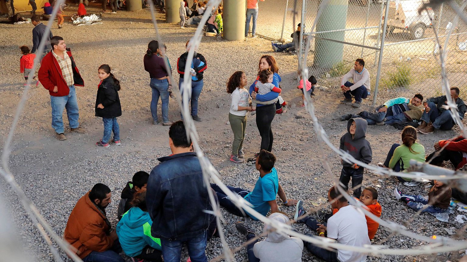 Image: Migrants from Central America wait inside of an enclosure, where the