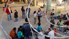 Image: Migrants from Central America wait inside of an enclosure, where the
