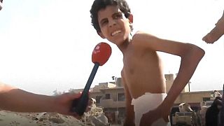 طفل مصاب يخرج من تحت أنقاض الموصل