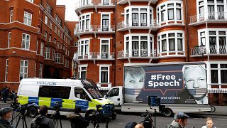 Image: A police van and truck outside the Ecuadorian Embassy in London