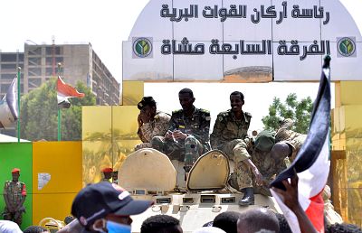 Sudanese military sit on their armoured personnel carrier after the defense minister announced a military council would run the country for a two-year transitional period.