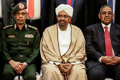 Sudan\'s President Omar al-Bashir, center, sits with his Defence Minister Awad Ibnouf, left,  and Prime Minister Mohamed Tahir Eila, right, at the presidential palace in Khartoum on March 14.