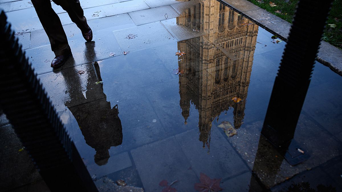 Image: The Houses of Parliament is reflected in an puddle in London, Englan