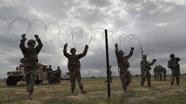 U.S. Army soldiers from Ft. Riley, Kansas string razor wire near the port o U.S. Army soldiers from Ft. Riley, Kansas string razor wire near the port o