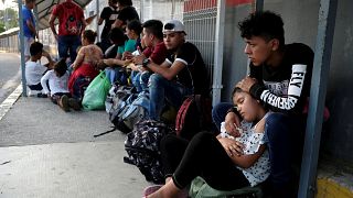 Image: Migrants from Honduras wait on the border bridge between Mexico and
