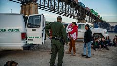 Image: A group of Brazilian migrants board a US Border Patrol van in Sunlan