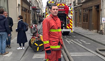 A firefighter stands next to his truck in Paris on Tuesday.