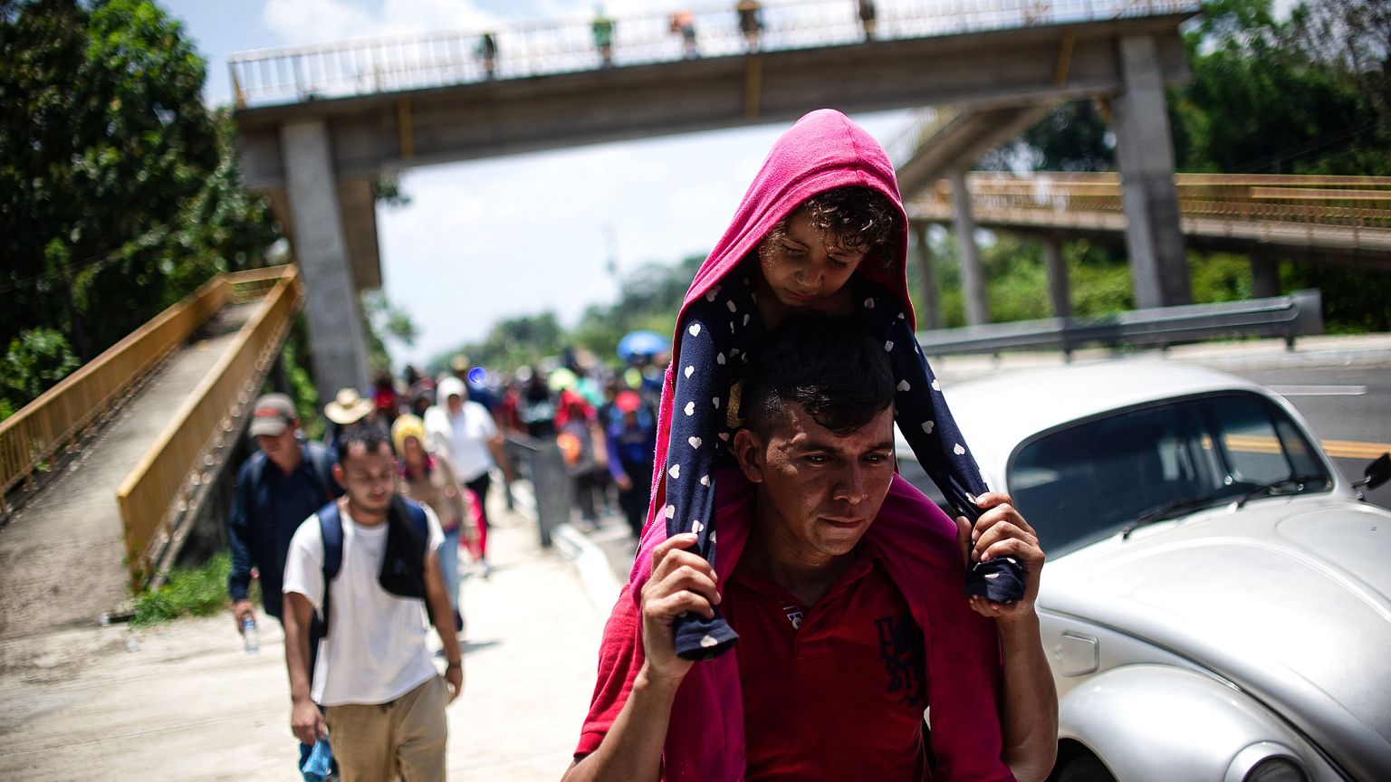 Image: Central American migrants traveling with a caravan rest on a road be
