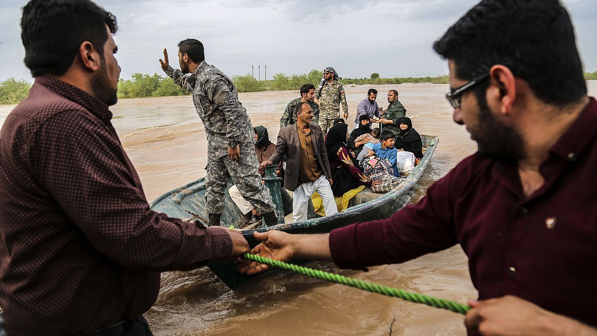 Image: Iranian soldiers help civilians in a flooded village near the city o